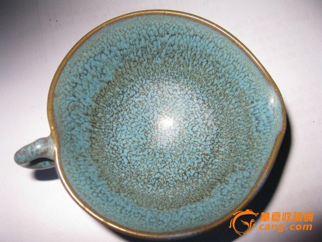 钧瓷酒盏规格:口径:8.4厘米 高:4.3厘米特征:胎质较粗松,呈灰白色积釉肥厚,浑浊失透,多棕眼,釉泡,光泽较差。施釉不到底,圈足宽厚外撇,内外无釉,足内胎面留有尖状痕迹。 从造型上看,属于日常生活用具,饮酒、饮茶、盛物、敬神、祭神、祭祖等物质生活和精神生活方面的使用。